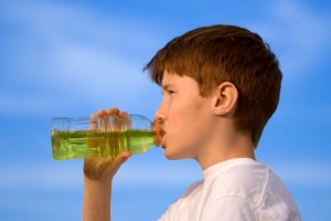 Boy is drinking over blue sky